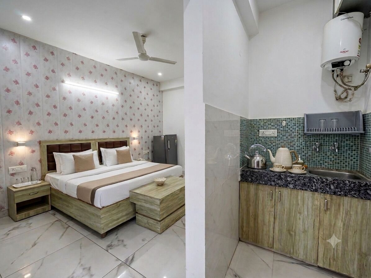 A bedroom with a bed, bedside tables, and a nightstand. There is a bathroom with a sink, mirror, and towel rack.