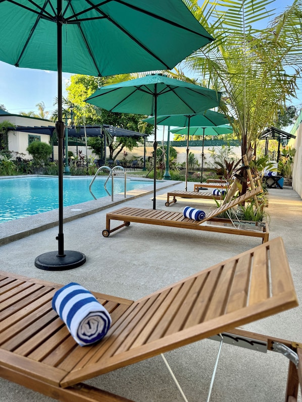 室外游泳池,開放時間為 07:00 至 19:00,提供泳池遮陽傘和日光浴躺椅