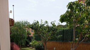A garden pathway with stepping stones, bordered by green plants and a brick wall. - Casa LiaRAMBLA MALLOLS 9, CASA LIA (L'Escala)