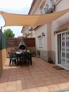 An outdoor patio with a grill, dining table, and chairs. - Casa LiaRAMBLA MALLOLS 9, CASA LIA (L'Escala)