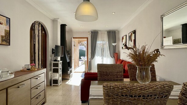A modern living room with a red sofa, wicker chairs, a TV, and a large mirror. - Casa LiaRAMBLA MALLOLS 9, CASA LIA (L'Escala)