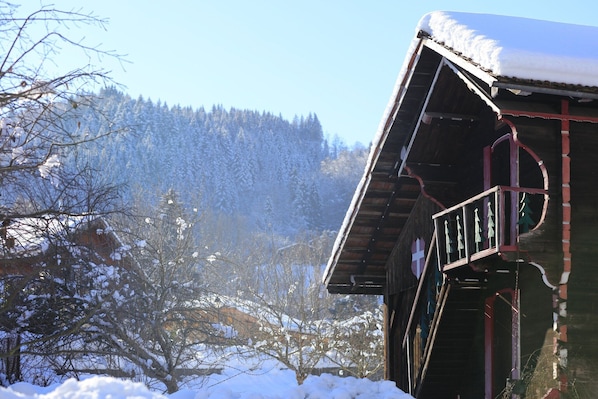 A wooden building with a snow-covered roof and a balcony. - Apartment in Morillon near Ski Slope (Morillon)