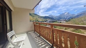Ein Balkon mit Holzgeländer, einem weißen Stuhl und einem Tisch.