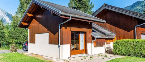 A wooden cabin with a sloped roof, a front door, and a small porch.
