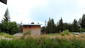 Un petit bâtiment en briques, entouré d’une forêt dense et d’arbres imposants.