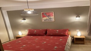 Une chambre à coucher avec un lit, deux tables de chevet et un panneau fixé au mur.