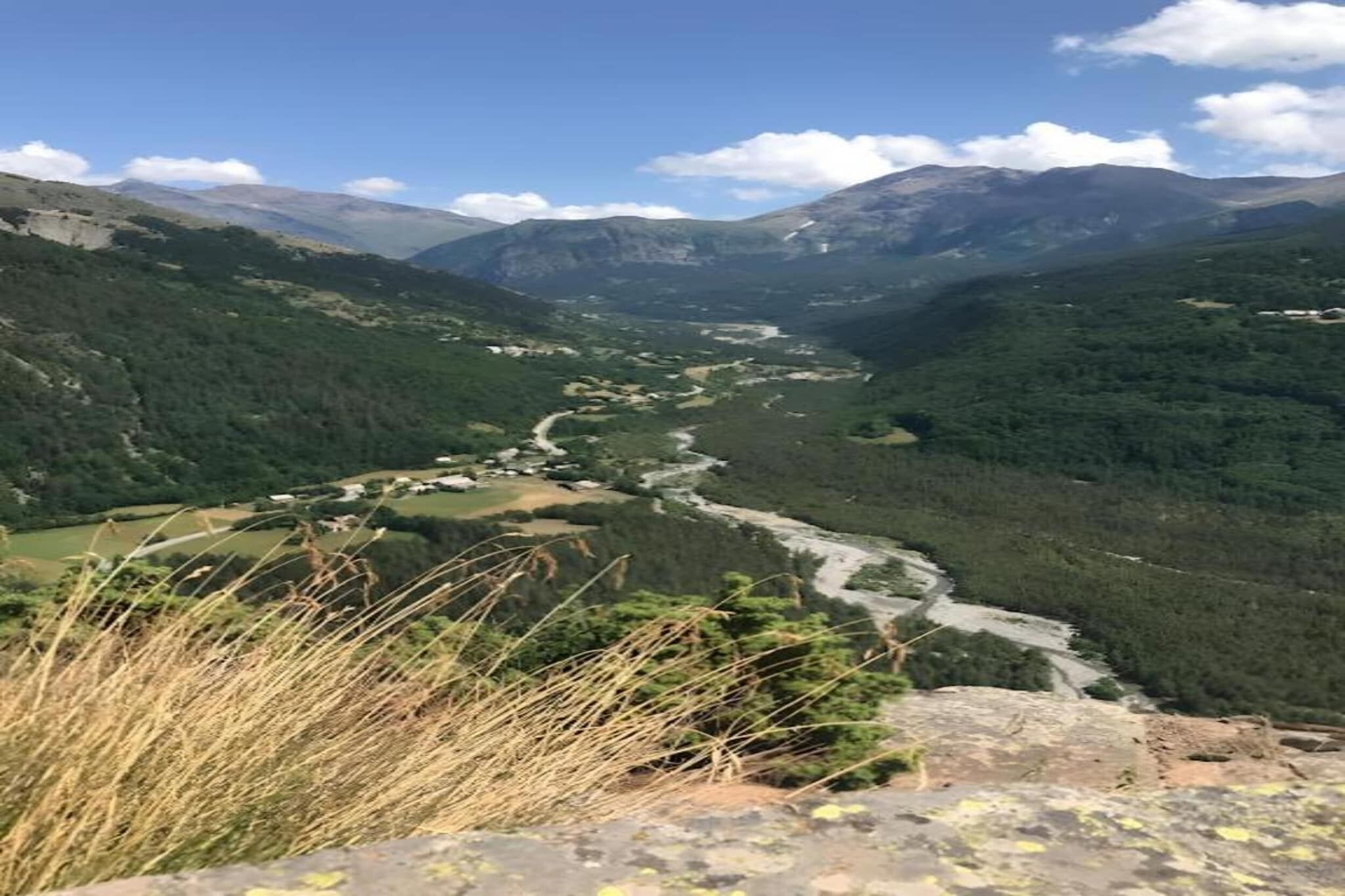 Een bergachtig landschap met een rivier die door een vallei stroomt.