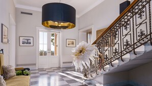 A grand staircase with ornate metal railings, a checkered floor, and a large white flower centerpiece.