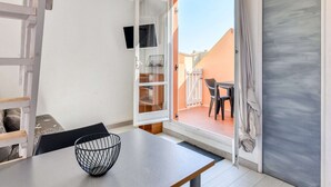 A modern room with a sliding glass door leading to an outdoor seating area. - Modern Stay by the Beach (Agde)