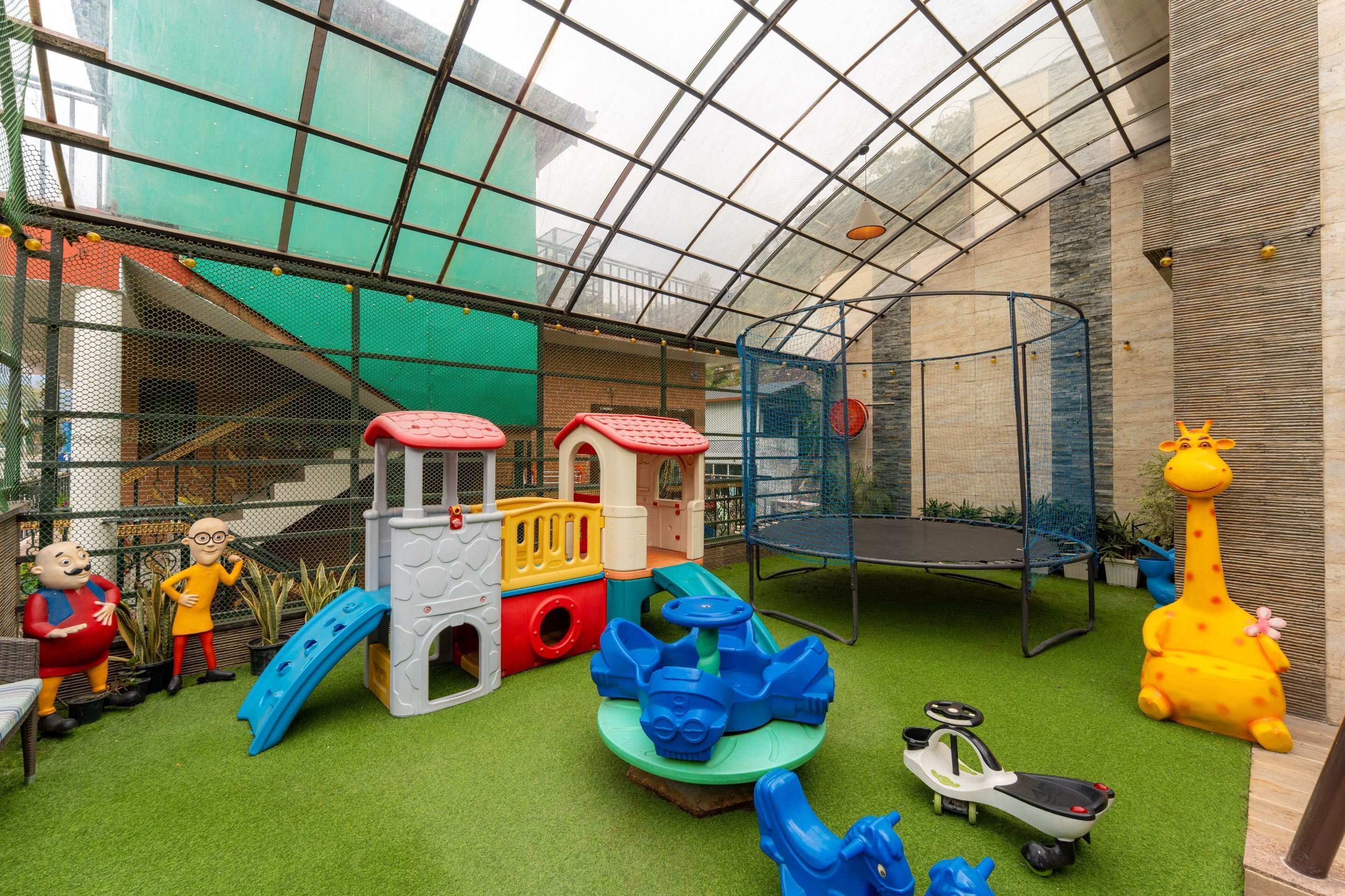 Un espace de jeux comprenant une structure d’escalade, des toboggans et un trampoline.