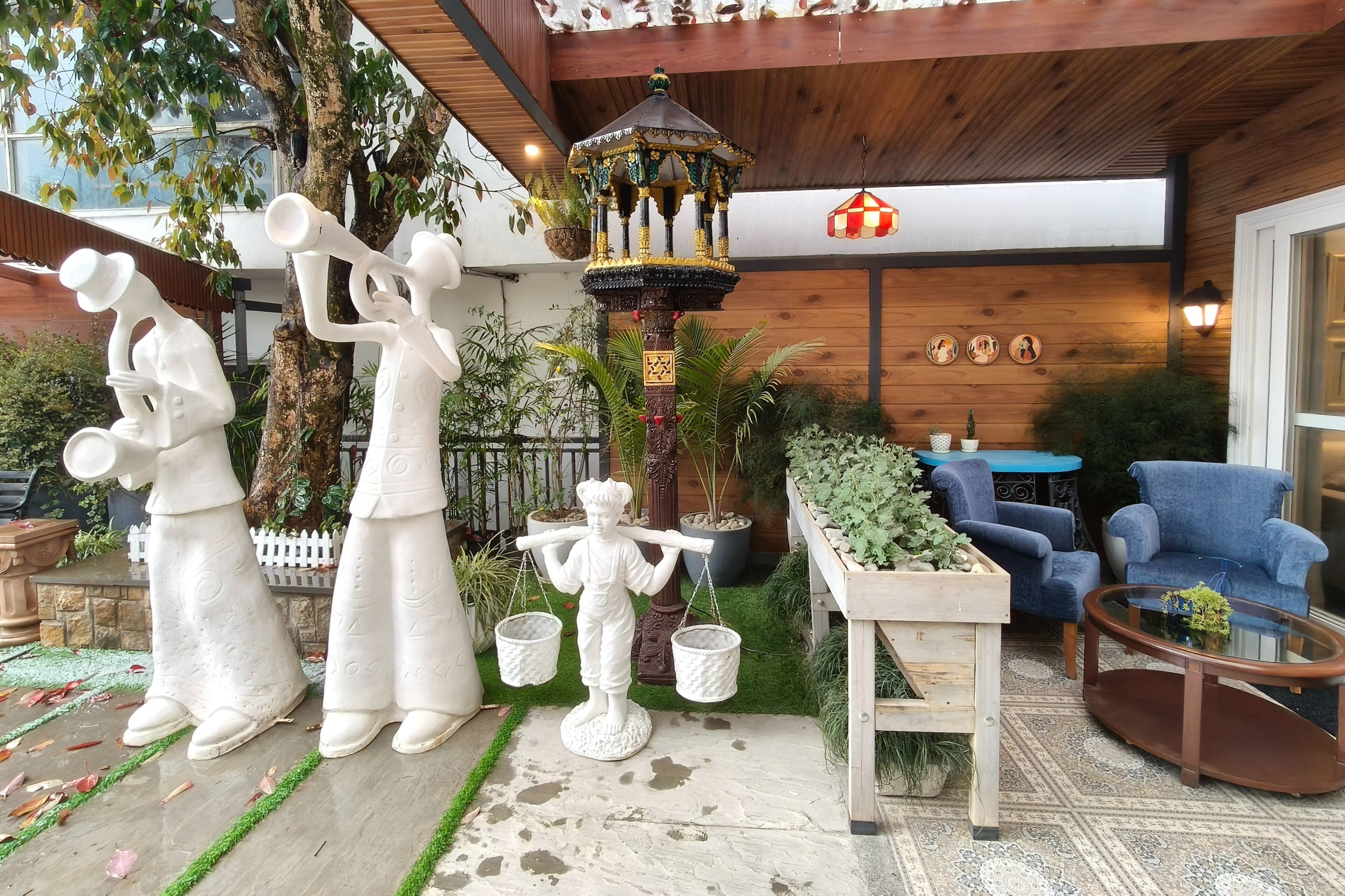 A garden area with a gazebo, outdoor seating, and decorative statues.