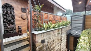 A modern outdoor area with a wooden wall, stone steps, and a metal fence. - Moustache Mussoorie (Uttarakhand)
