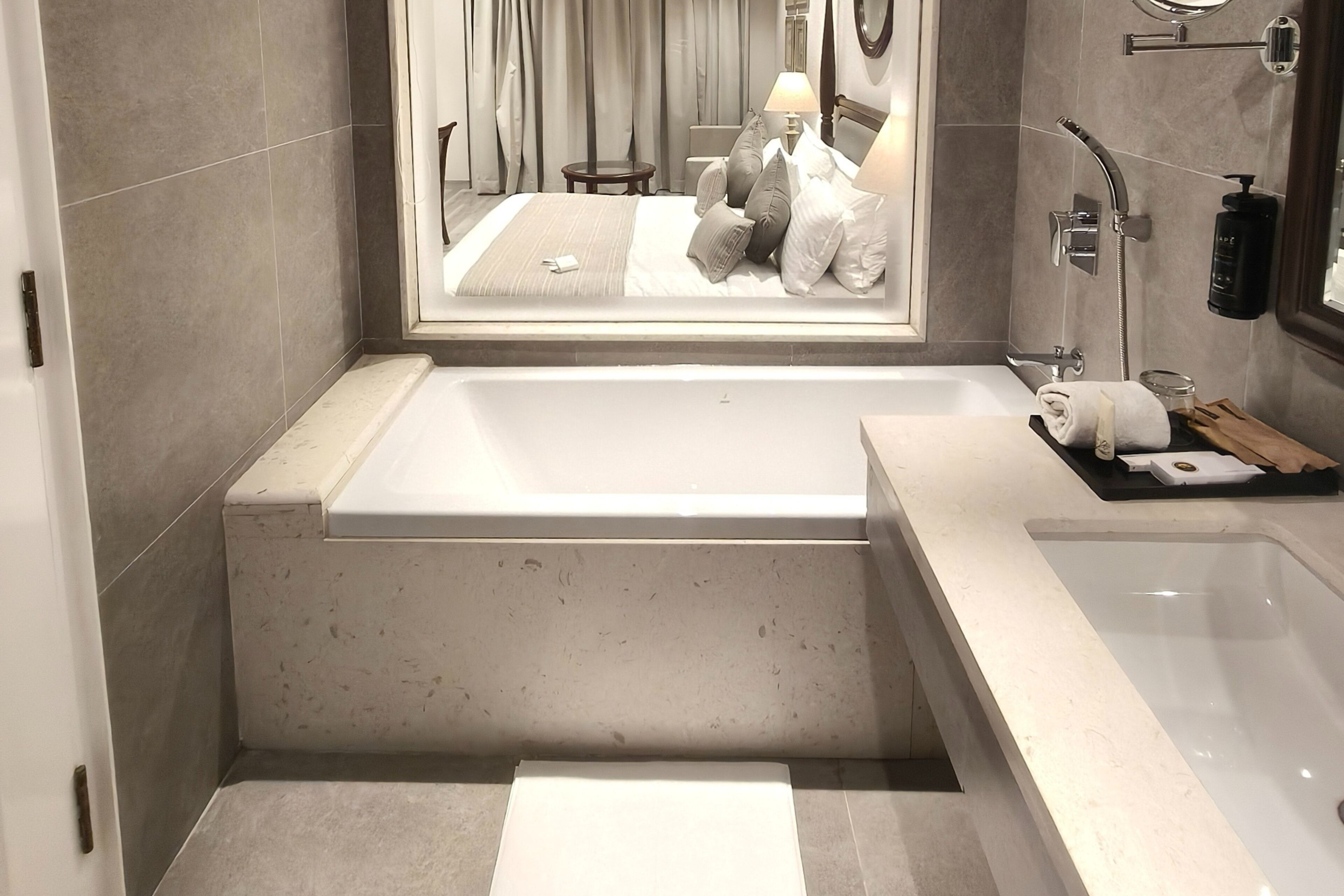 Ein modernes Badezimmer mit einer großen Badewanne, einer separaten Duschkabine und einem Waschtisch mit Spiegel.
