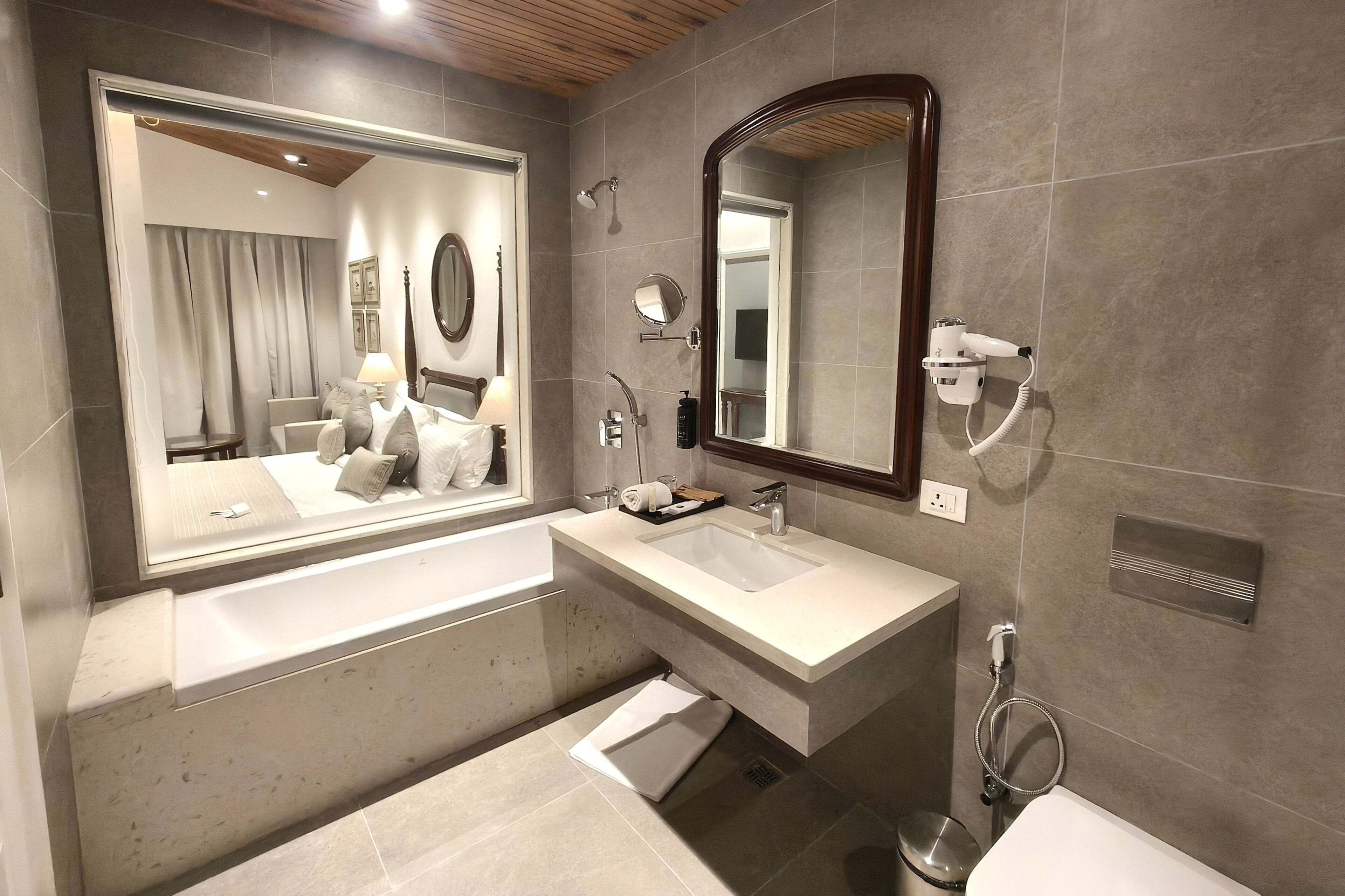 Een moderne badkamer met een grote spiegel, twee wasbakken en een douche.