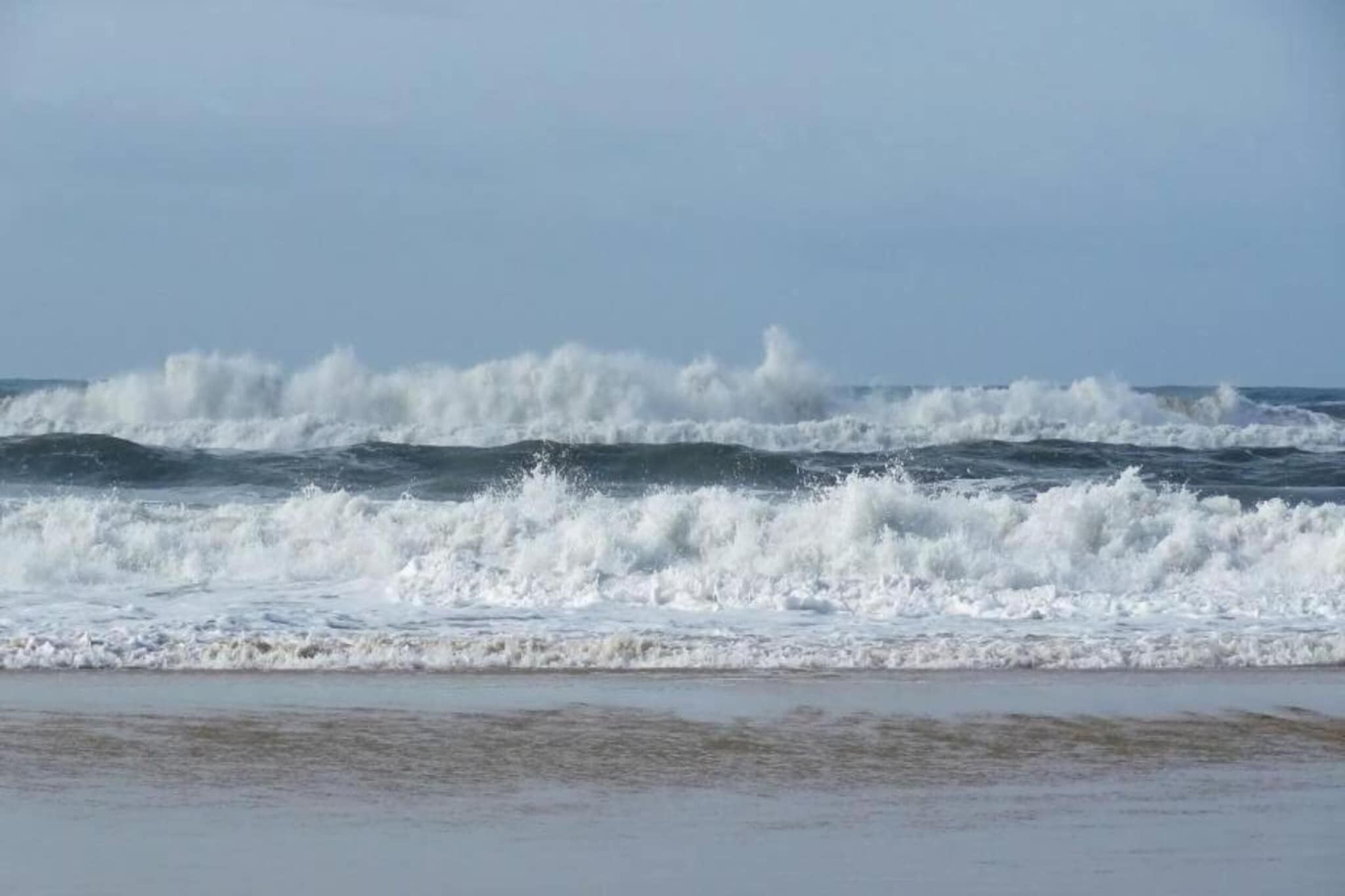 A beach with waves crashing onto the shore.