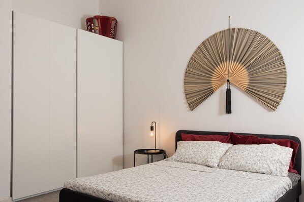 A bedroom with a bed, a nightstand, a wall-mounted fan, and a wardrobe. - Design Lab - New Exclusive Apartment (Milano)