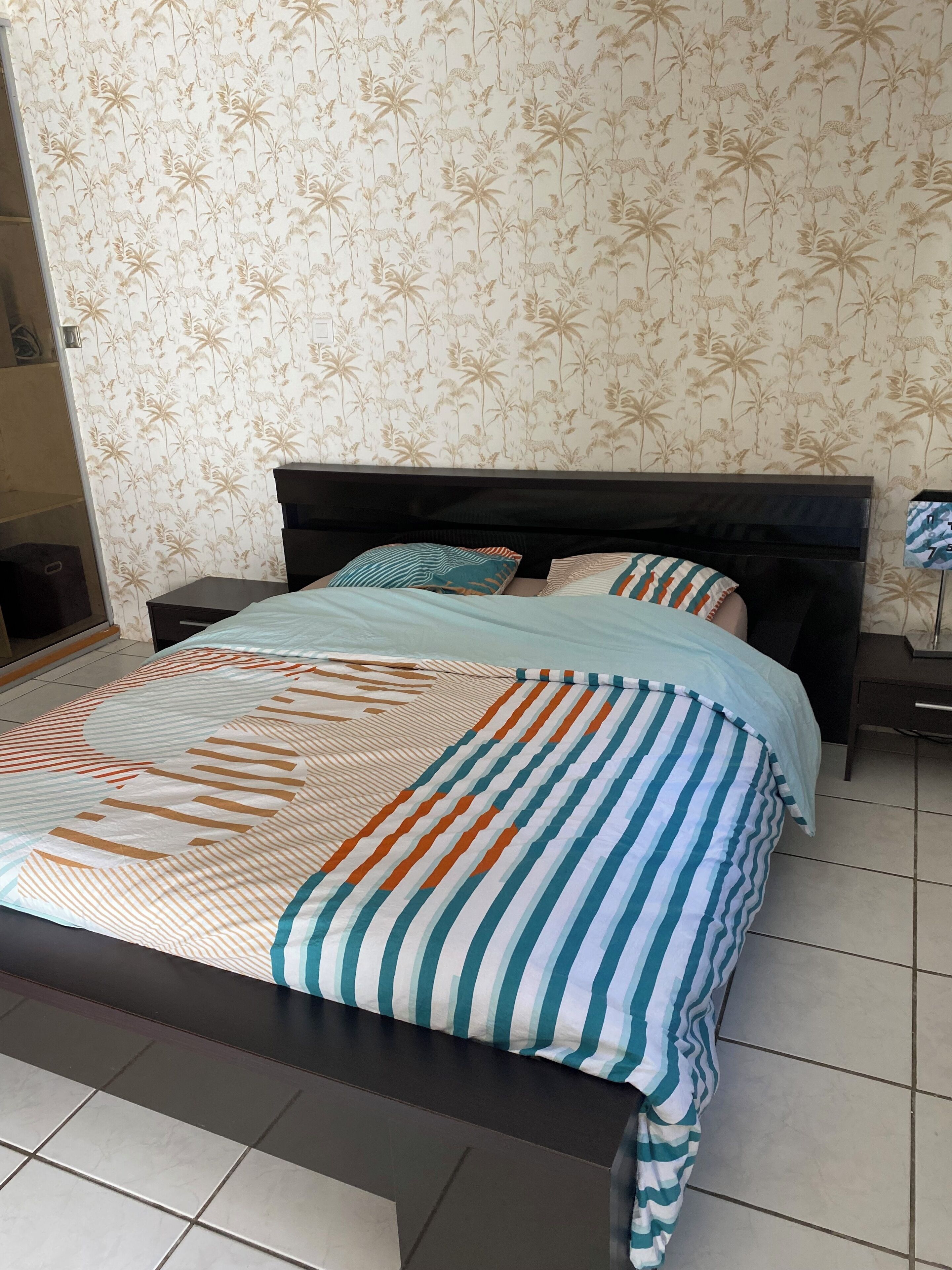 A bed with a striped bedspread and a headboard.