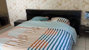 A bed with a striped bedspread and a headboard.