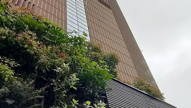 Un edificio alto de diseño moderno, con una combinación de paneles de vidrio y metal.