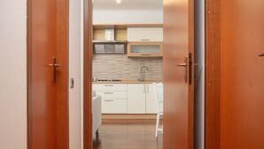 Una cocina moderna con armarios blancos, un lavamanos de acero inoxidable y una encimera de madera.