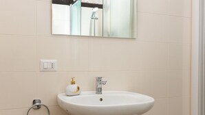 A bathroom with a white sink, a mirror above it, and a toilet. - Kandinsky - Exclusive Apartment (Milano)