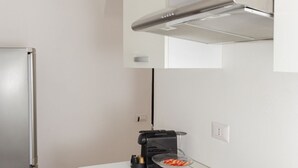 A modern kitchen with a built-in espresso machine, a glass coffee pot, and a white countertop. - Kandinsky - Exclusive Apartment (Milano)