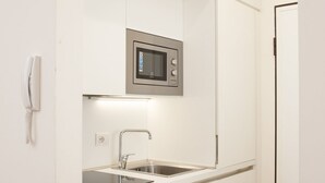 A modern kitchen with a built-in microwave, a sink, and a telephone. - Klimt Central station - Two Room Apartment (Milano)