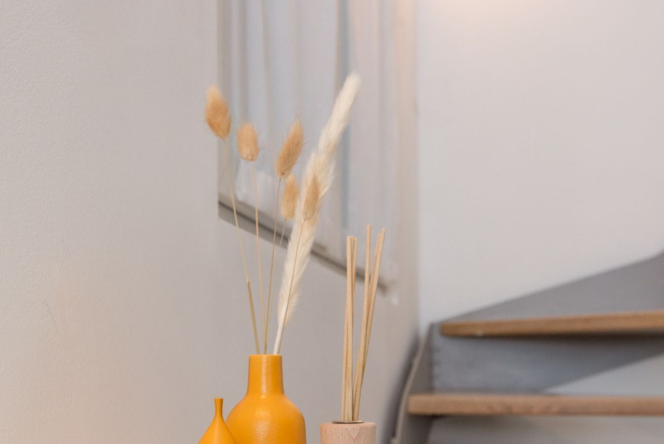 Three vases with reed sticks on a table.