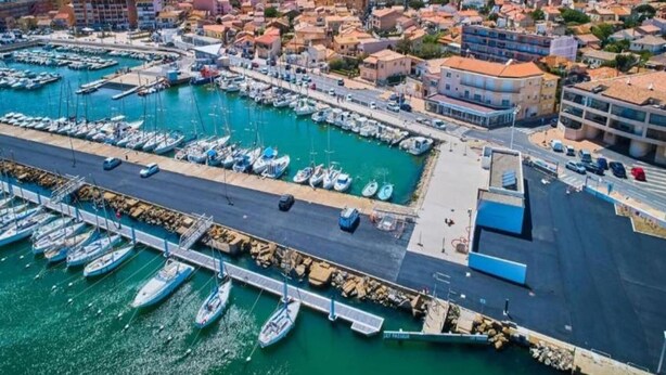 An aerial view of a coastal town with a marina, buildings, and a clear sky. - Bright Retreat Near Beach (Sérignan)