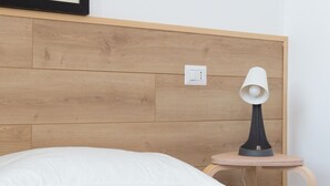 A bed with white pillows and a bedside table with a lamp. - New Exclusive Melegnano Apartments- Near train station X4 (Melegnano)
