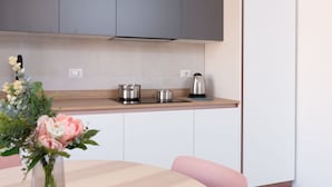 A modern kitchen with grey cabinets, a wooden countertop, and a vase with flowers on the table. - New Exclusive Melegnano Apartments- Near train station X4 (Melegnano)
