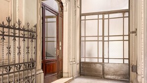 A hallway with a wooden door and a large frosted glass window. - Piazza del Carmine - Gold Exclusive Apartment - APARTMENT IN THE UNDERGROUND (Milano)