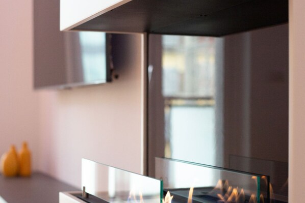 A modern kitchen with a glass-top stove and a stainless steel range hood.