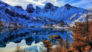 A snow-covered mountain landscape with a clear lake reflecting the mountains. - Apartment in French Alps near Ski Resort (Allos)