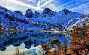 Un paysage montagneux avec un lac dans lequel se reflètent les sommets.