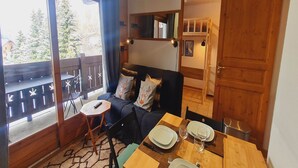 Una habitación acogedora con un sofá, una mesita y un comedor.