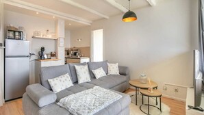 A modern living room with a grey sofa, a coffee table, and a television. - Alpine Escape at Chamrousse (Chamrousse)