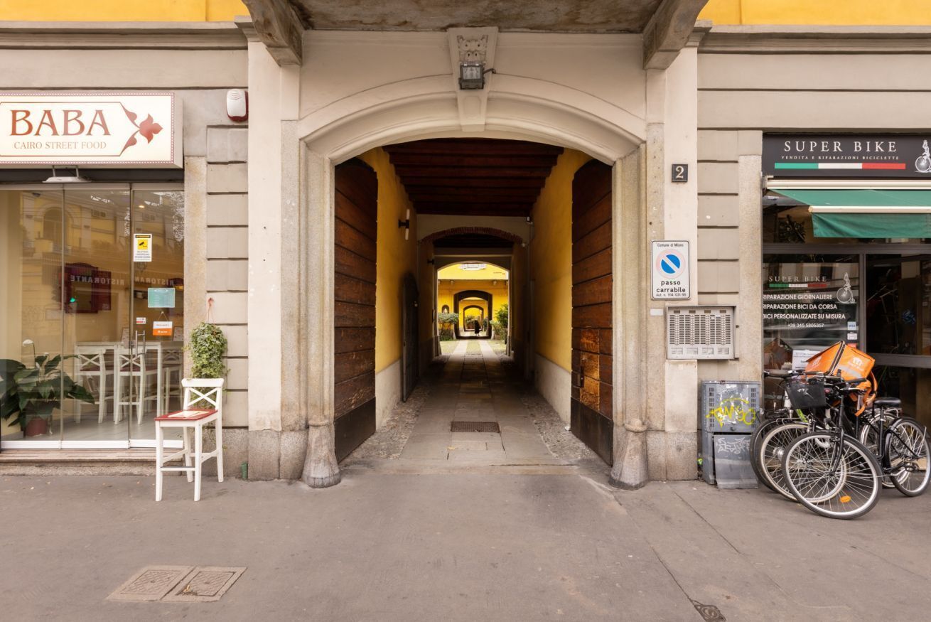 A narrow alleyway with a storefront on the left labeled 'BABA CAIRO STREET FOOD' and a bicycle shop on the right.