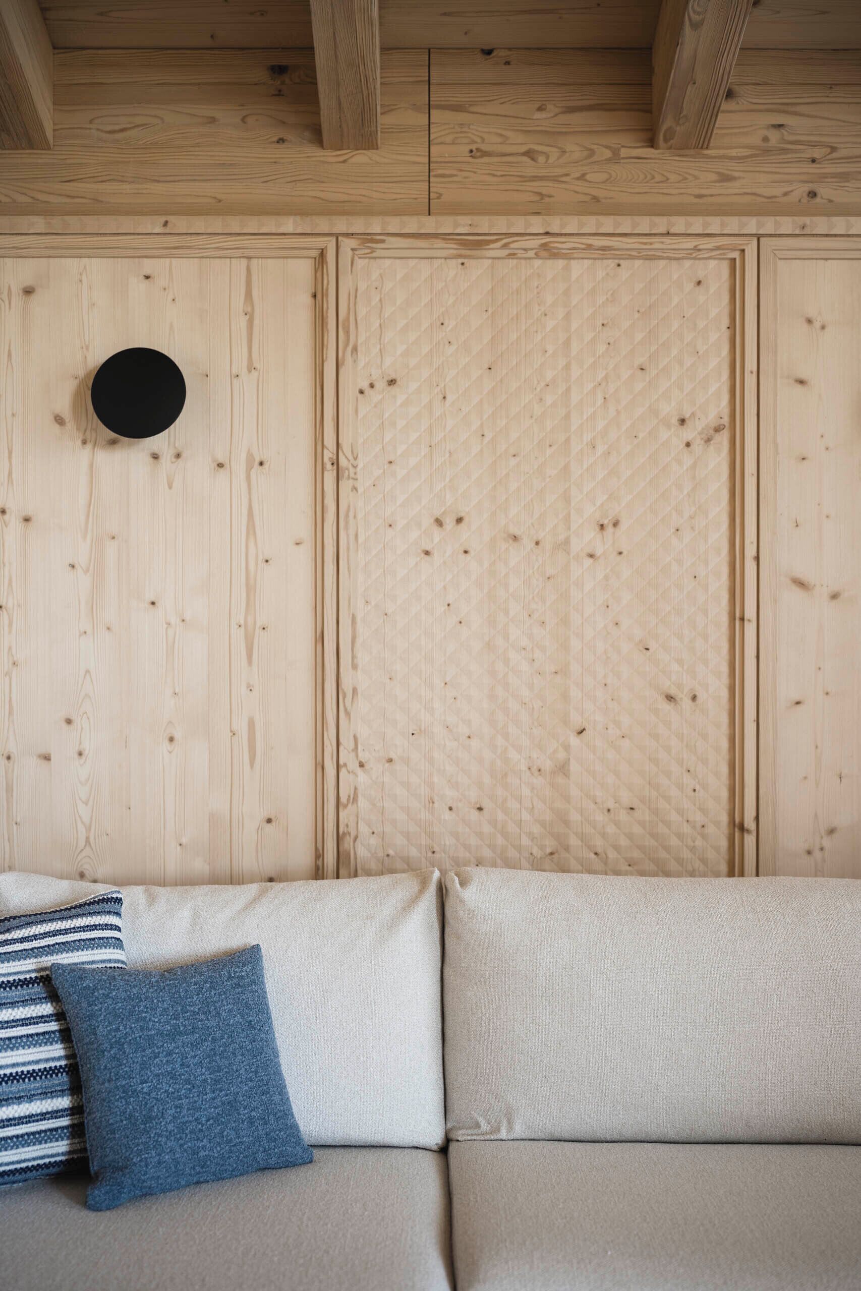 Un mur en bois avec un panneau matelassé et une découpe circulaire.