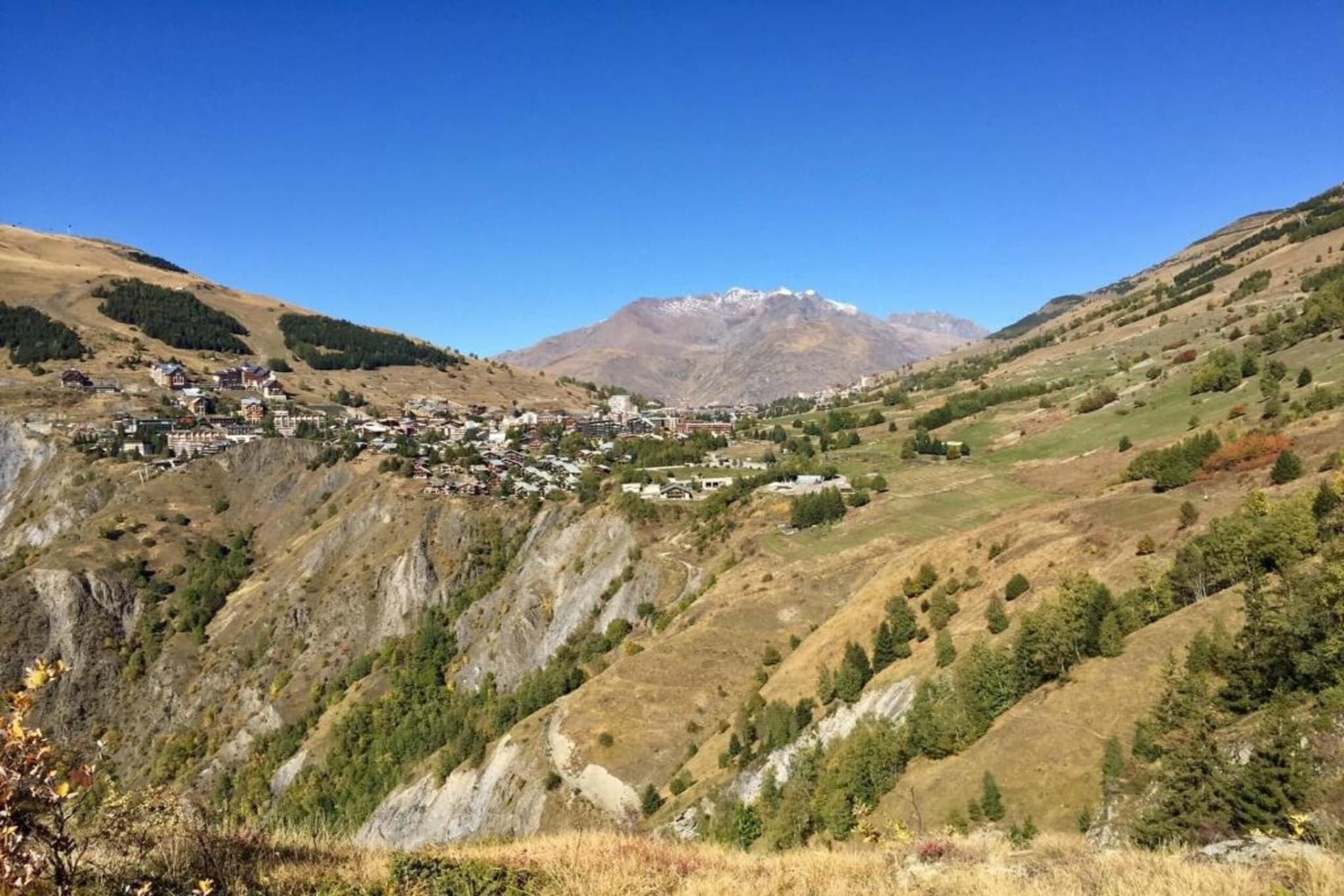 Un paysage montagneux avec un village niché au fond de la vallée.