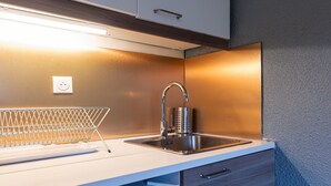 A modern kitchen with a stainless steel sink, a wire rack, and a drawer.