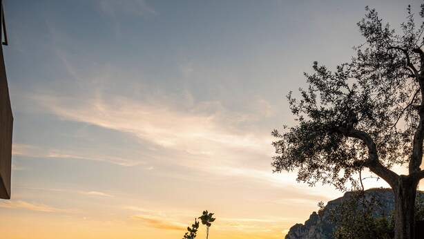 A coastal view with a sunset, a stone staircase, and a railing overlooking the sea. - Antalia Boutique Hotel (Positano)