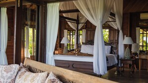 A spacious bedroom with a large bed, a wooden ceiling, and a canopy bed. - A hidden gem, away from the hustle and bustle of everyday life. (Karangasem)