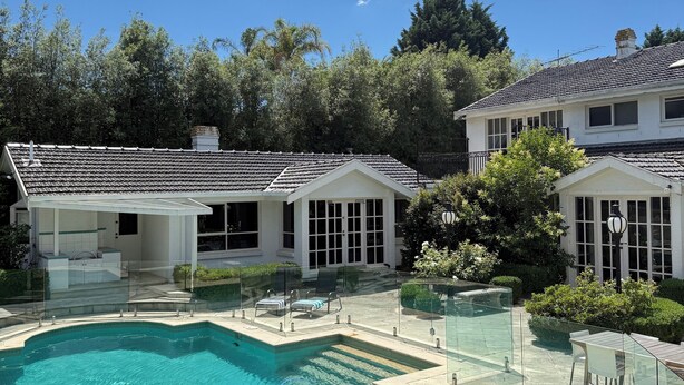 A swimming pool with a glass enclosure, surrounded by a patio area with outdoor furniture. - Templestowe Luxe Retreat | Pool, Tennis Court & Private Oasis (Templestowe)