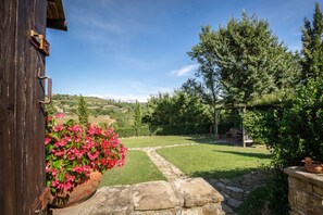 A rustic wooden building with a stone pathway leading to a lush garden. - My Exclusive Italy - Authentic Chianti's Villa with Private Pool and view (Panzano In Chianti)