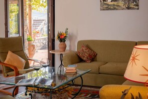 Una sala de estar acogedora con una mesa de centro de vidrio, un sofá y una lámpara.