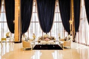 A luxurious room with a large window, elegant furniture, and a chandelier.