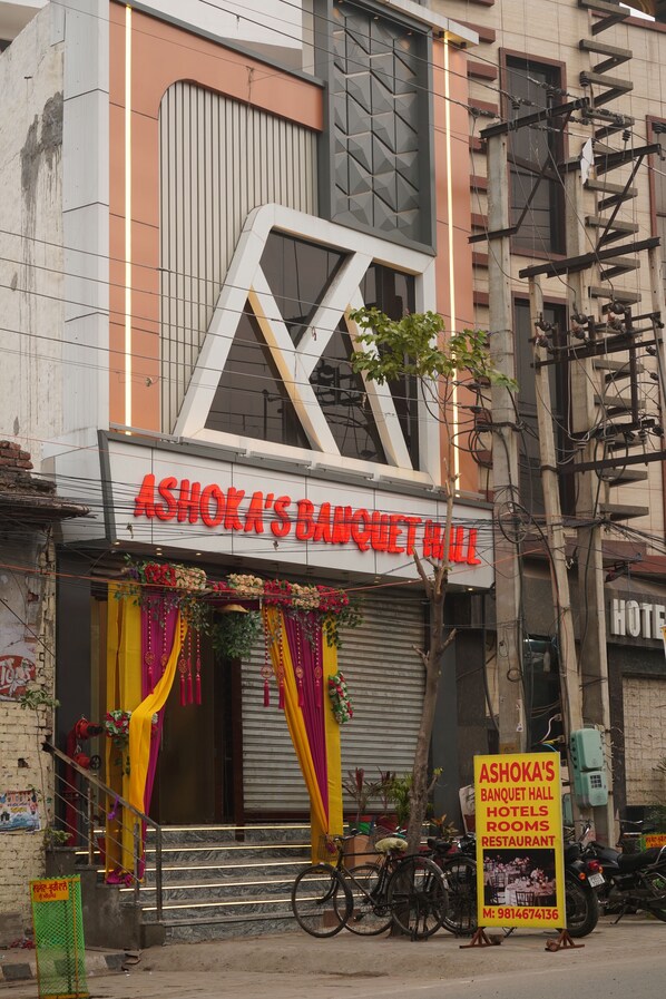 Un edificio con un letrero que dice "Ashoka's Banquet Hall Hotels Rooms Restaurant".