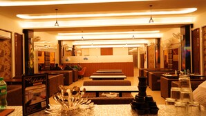 A restaurant with booths and tables, overhead lighting, and a menu stand.