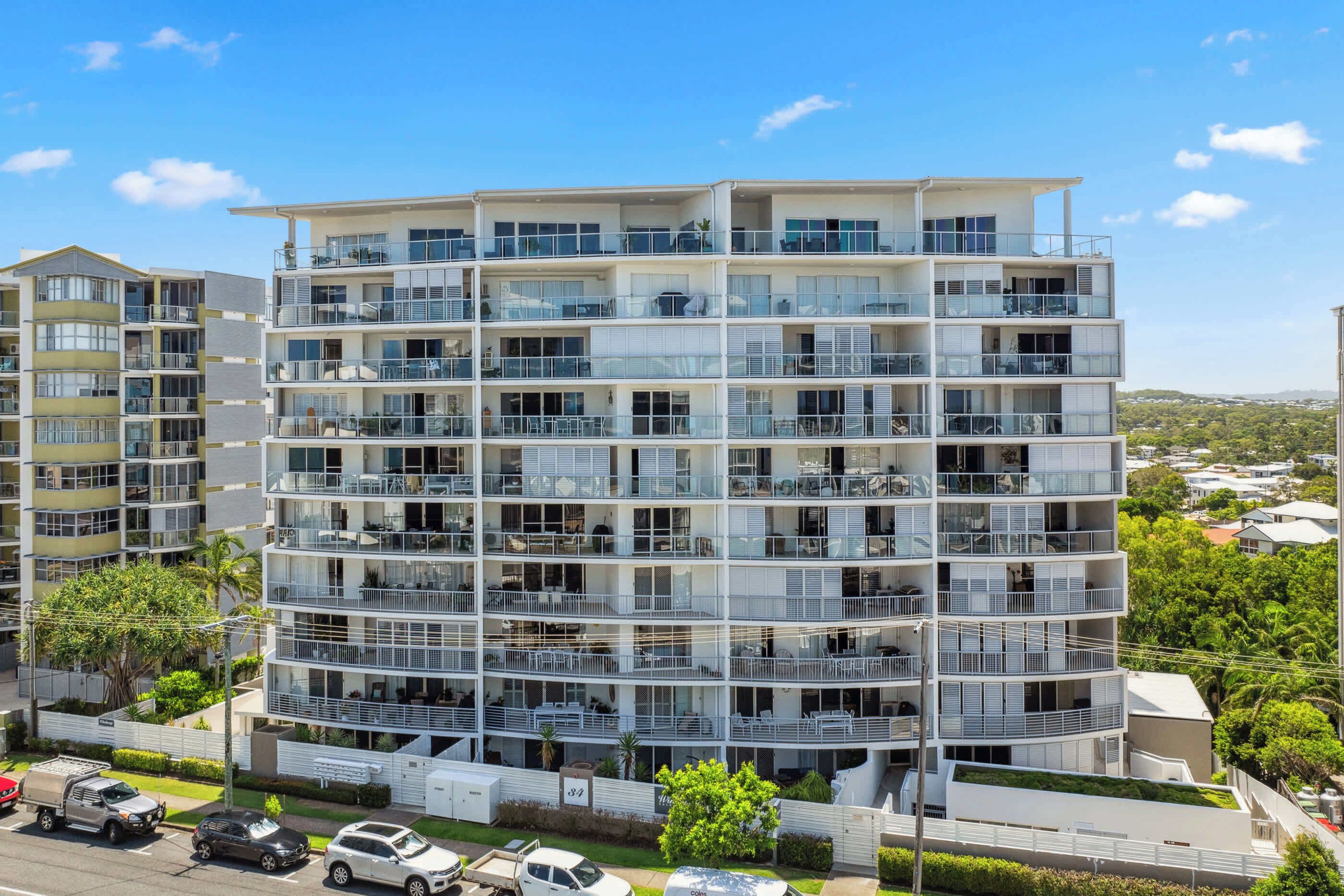 Un immeuble résidentiel à plusieurs étages, doté de balcons, de grandes fenêtres et d’un toit plat.